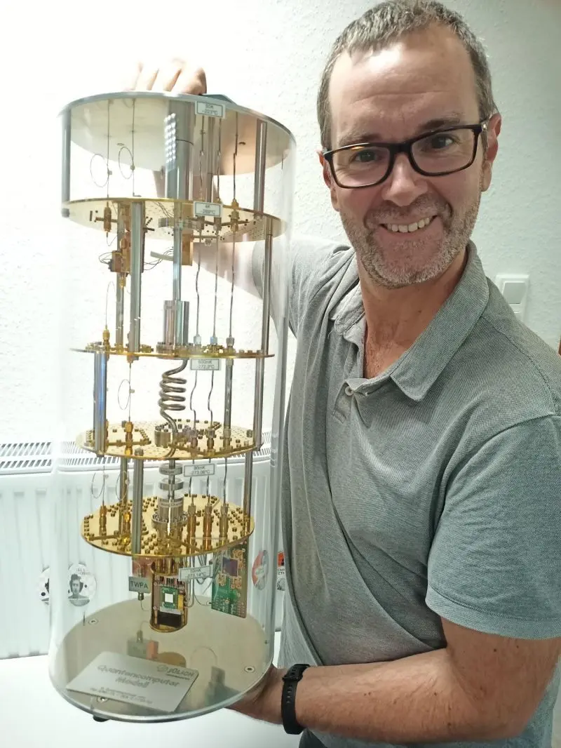 Julen Larrucea holding a model of a quantum-computing dilution refrigerator from the Peter Grünberg Institute.
